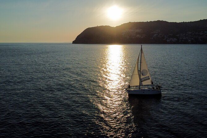 Sailing at sunset along the cliffs of Maro-Compartida - The Sum Up